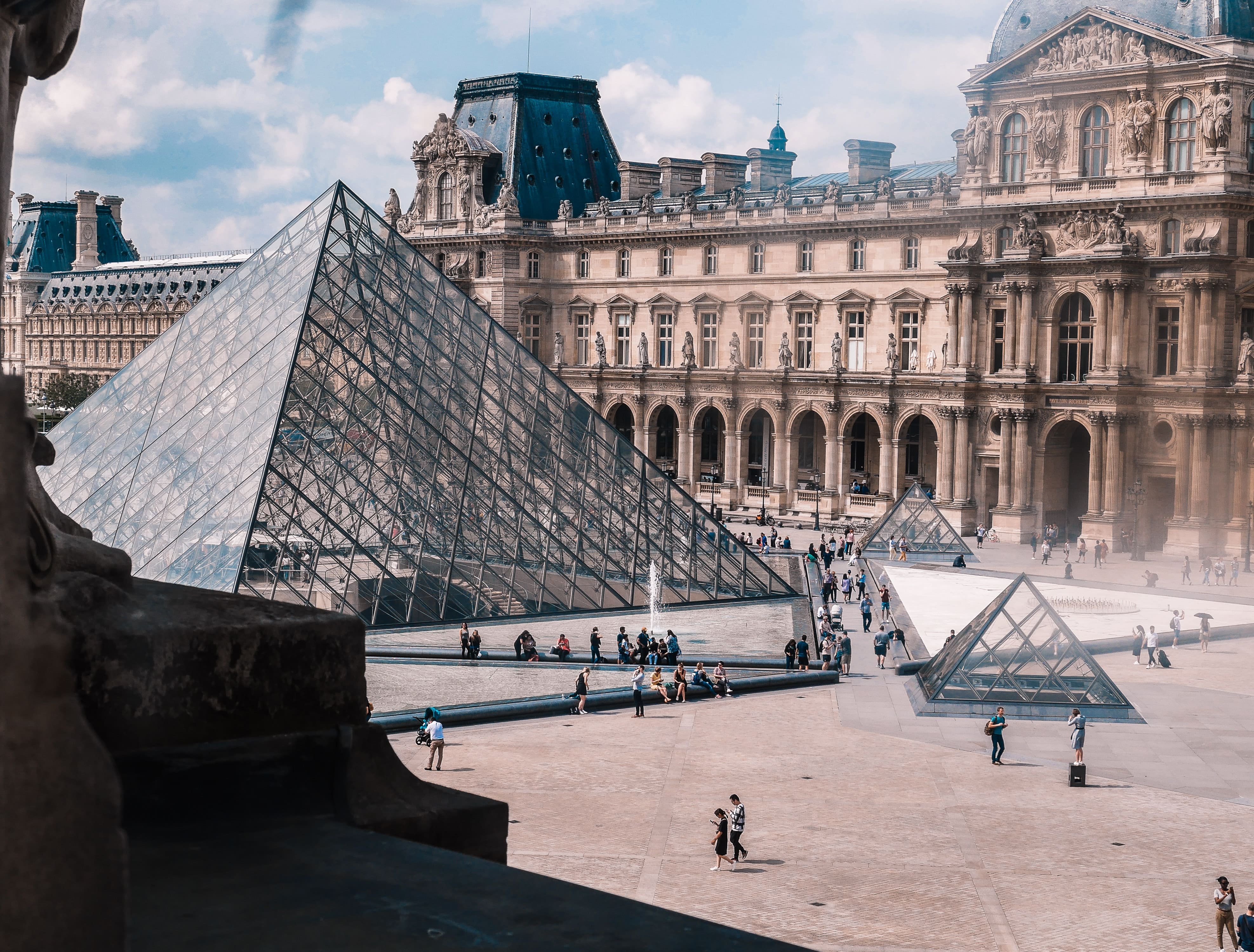 Aerial view of Louvre, Paris, with people exploring, epitomizing PEO in France