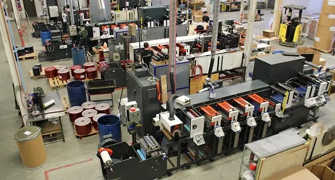 Tamperguard manufacturing facility producing tamper-evident tapes and security packaging materials on a high-volume production line.