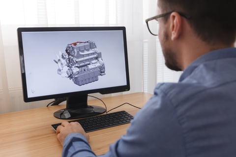 engineer reviewing automotive engine design on computer for European market expansion