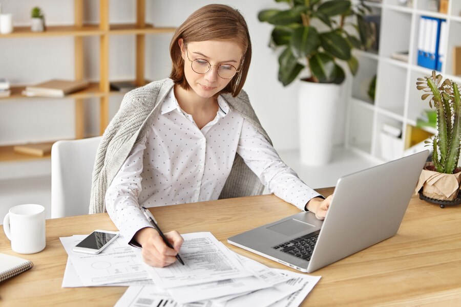 elegant-businesswoman-dressed-formally-sitting-with-laptop_273609-4748